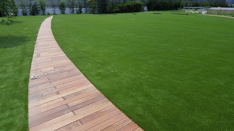 prato in erba sintetica con sentiero in legno