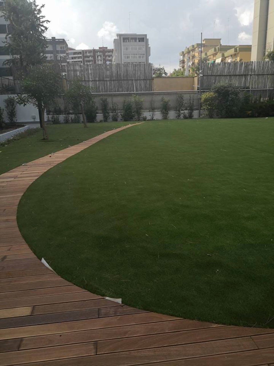 giardino con erba sintetica e sentiero in legno