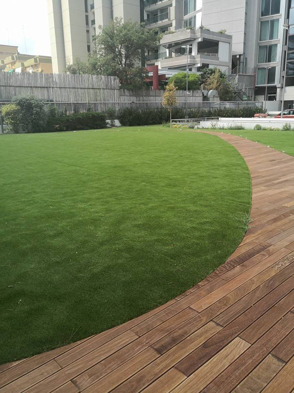 area esterna con erba sintetica e sentiero in legno