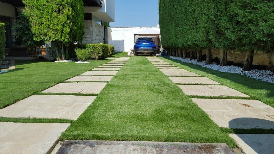 giardino con erba sintetica e sentieri in pietra