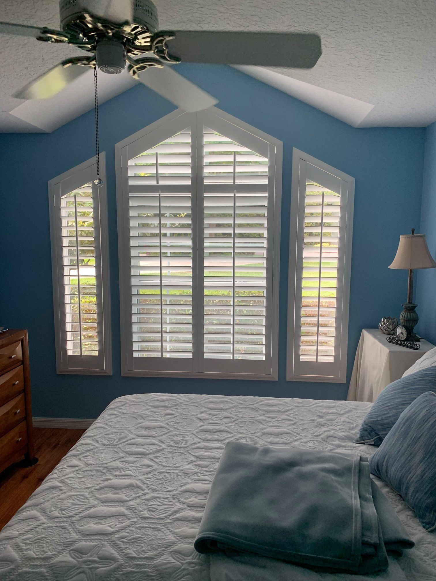 A living room with arched windows and shutters on the windows — Deland, FL — Island Shutter Company