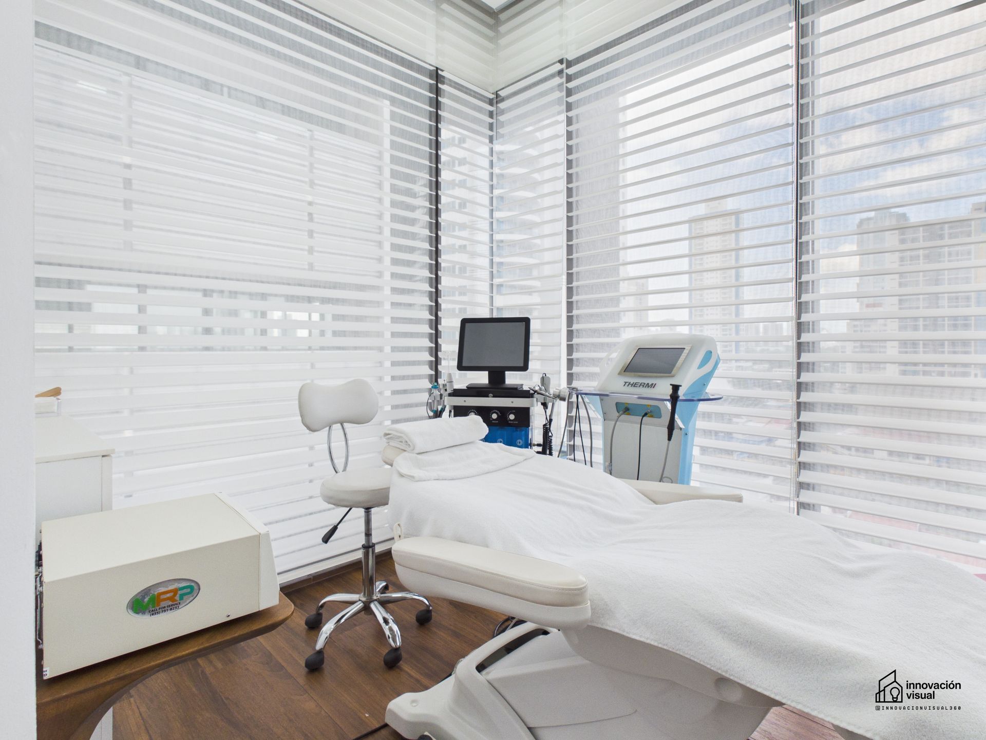 Living room with dark gray sofas, round coffee table, and large windows.