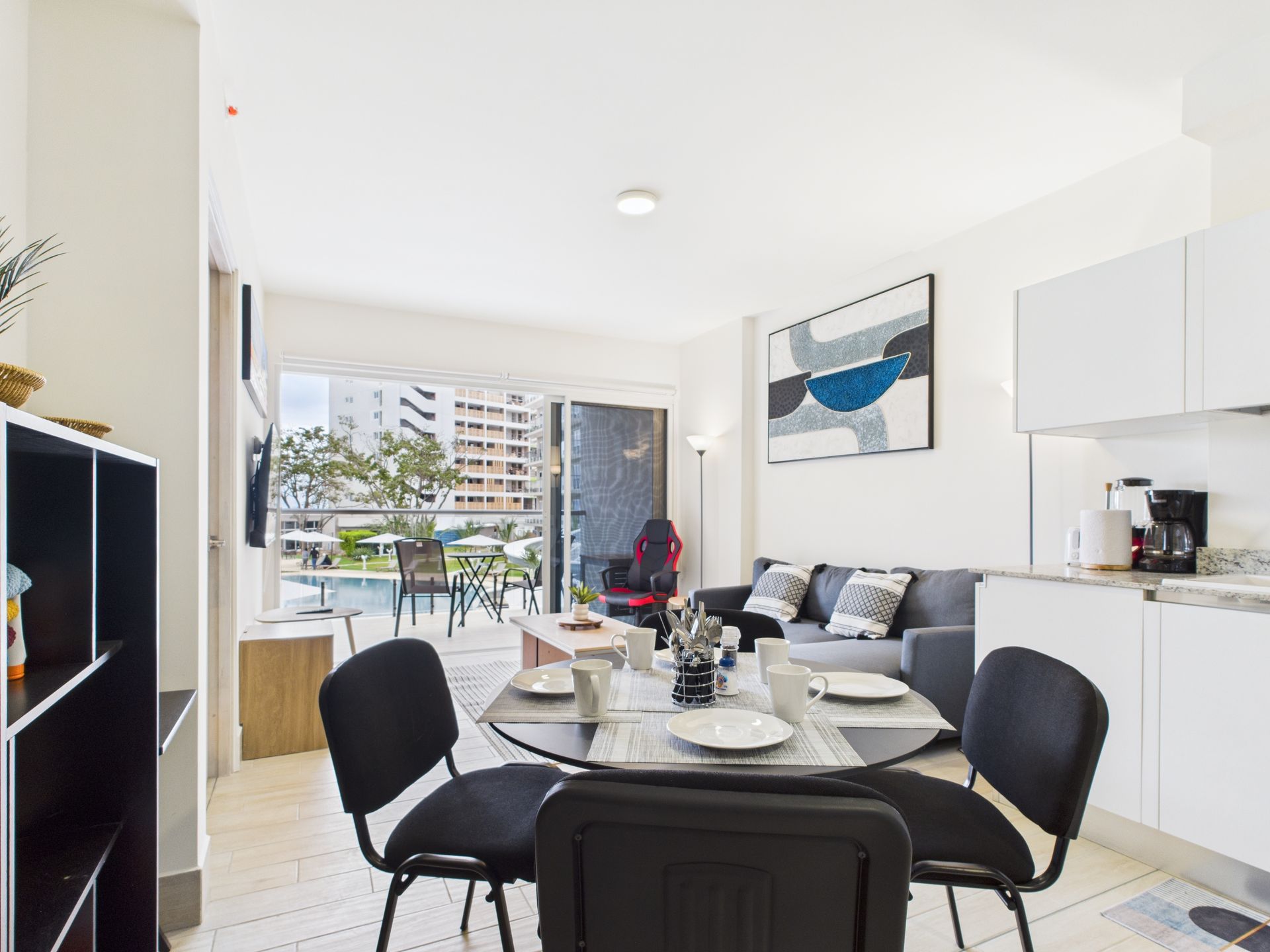Interior of an apartment with dining area, kitchen, and open access to balcony. Modern decor.