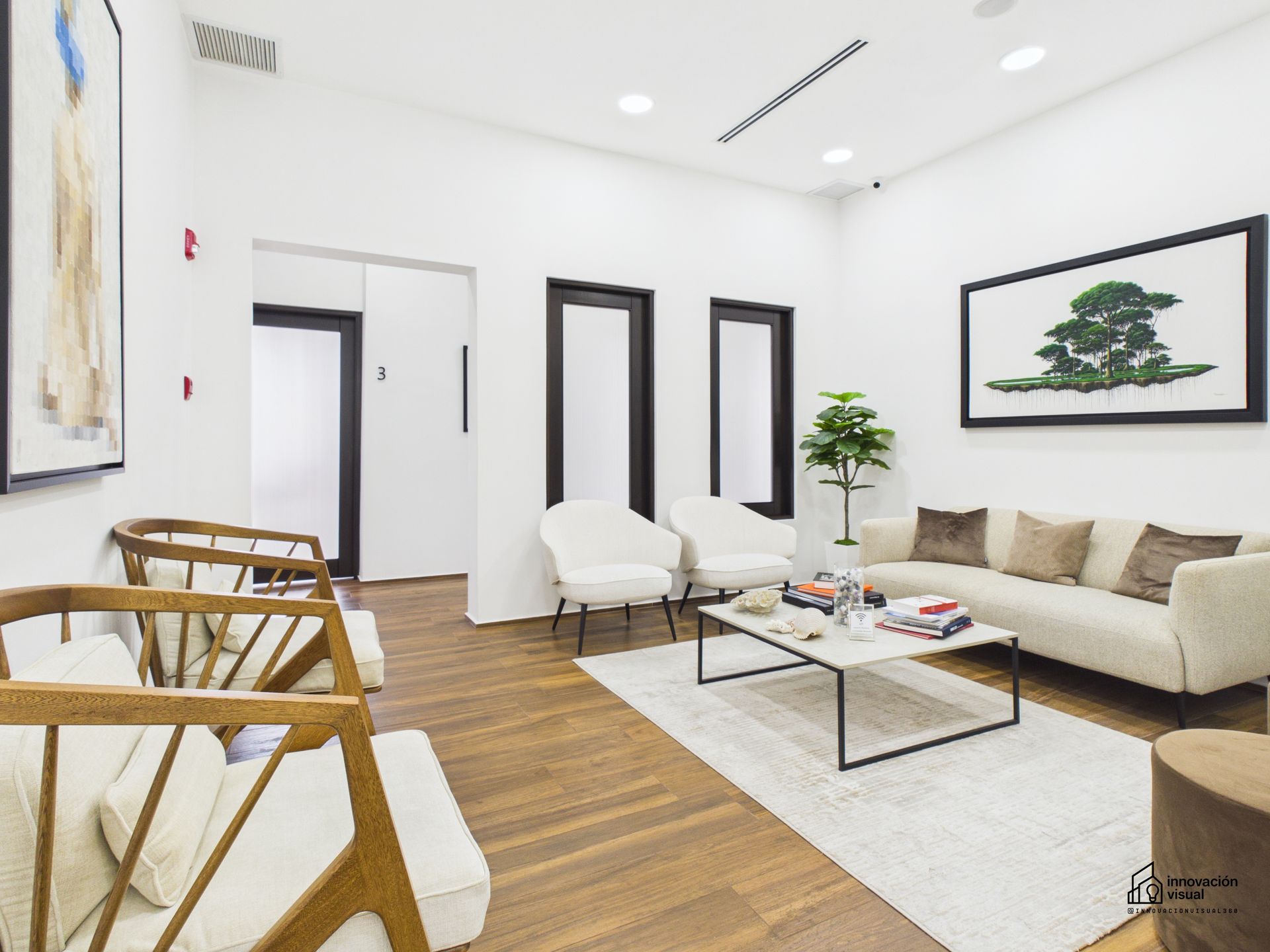 Bright office with city view, desk, plants, rug, guitar.