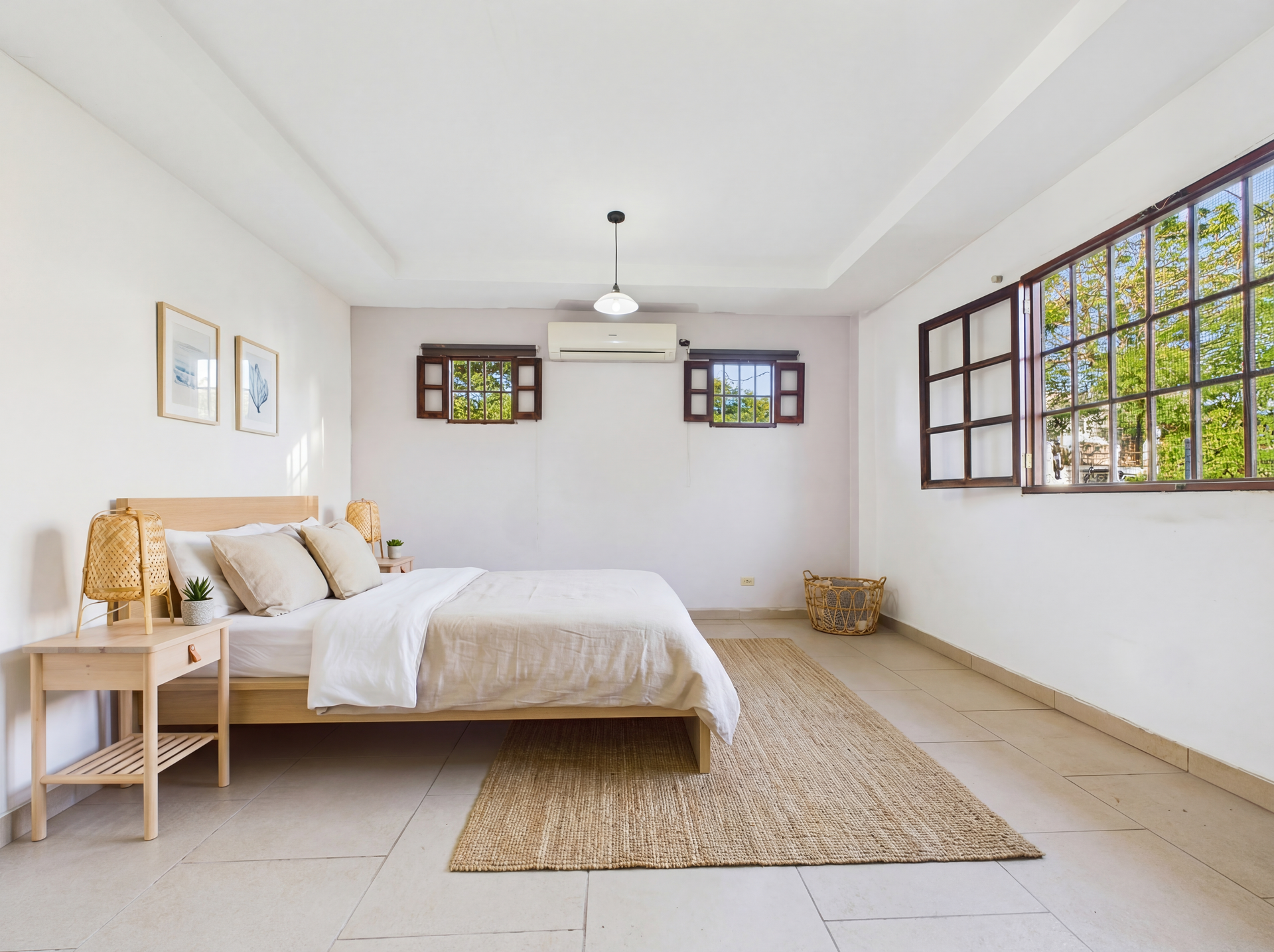 Dormitorio con cama, alfombra, ventanas y colores neutros.