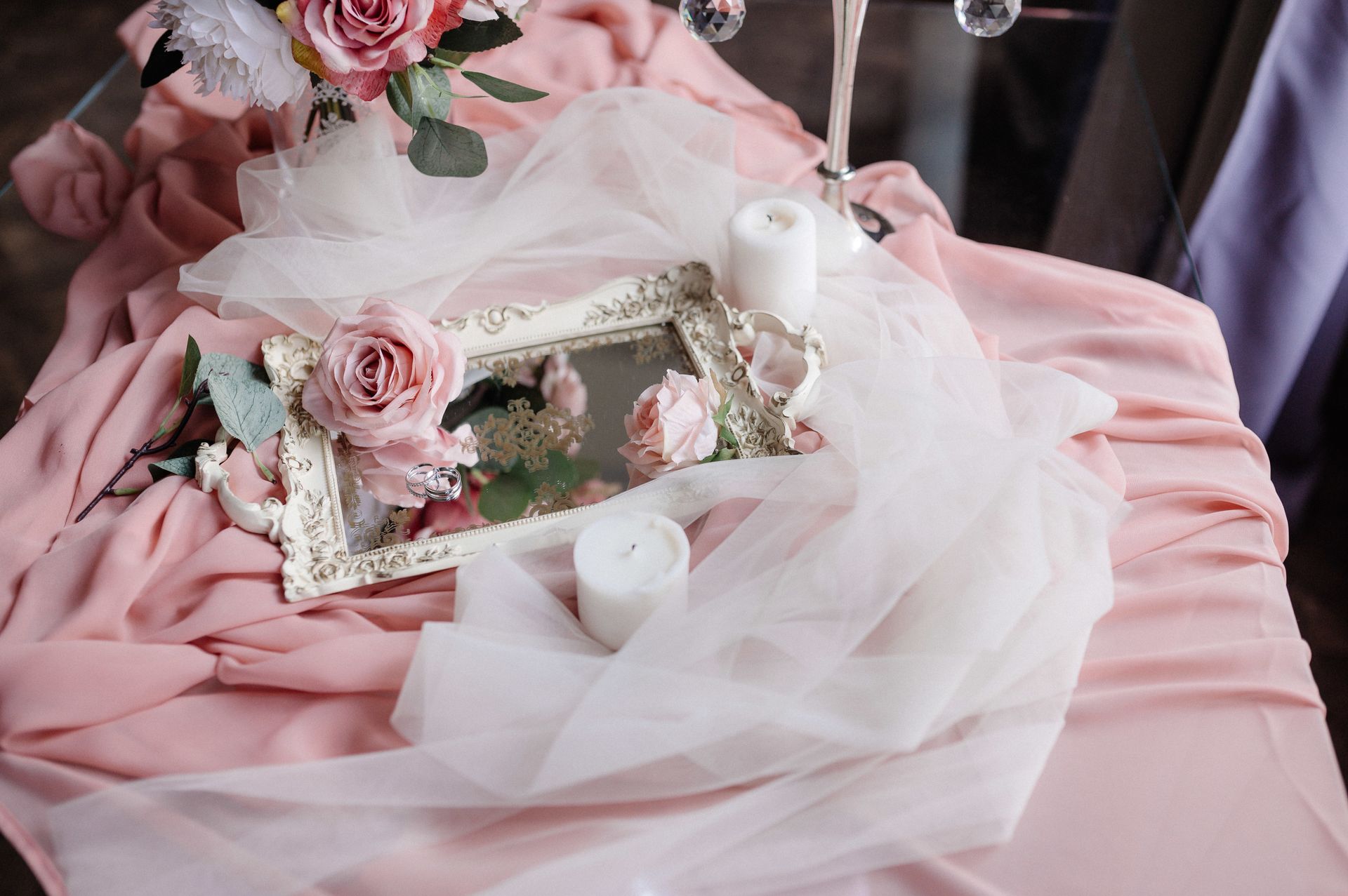 Un tavolo con fiori, candele e uno specchio sopra.