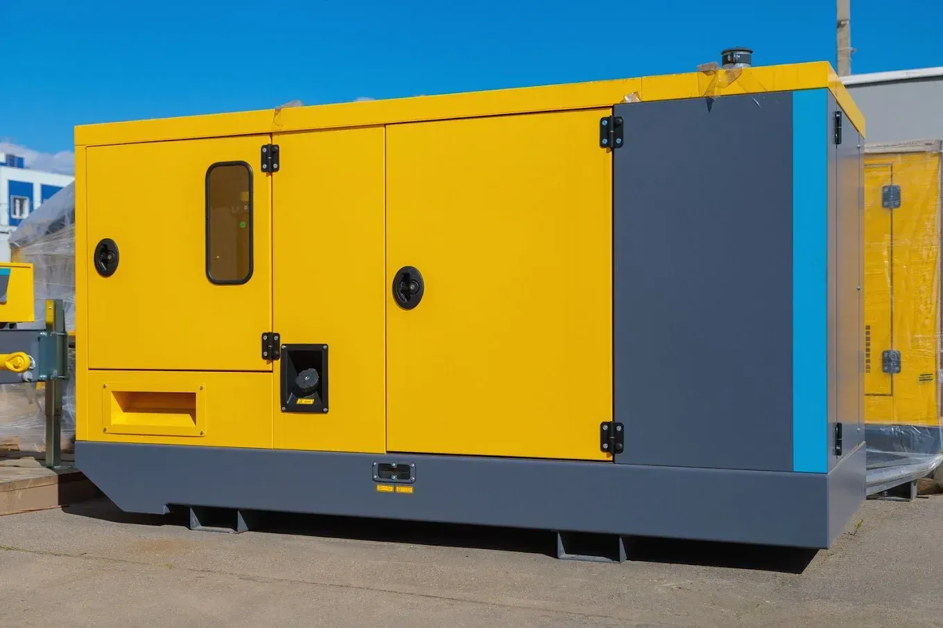 Yellow and gray industrial generator in an outdoor setting.
