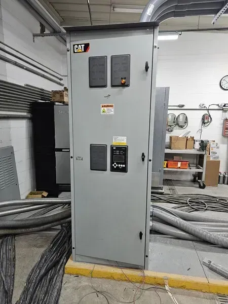 Gray electrical panel with CAT logo in an industrial setting.