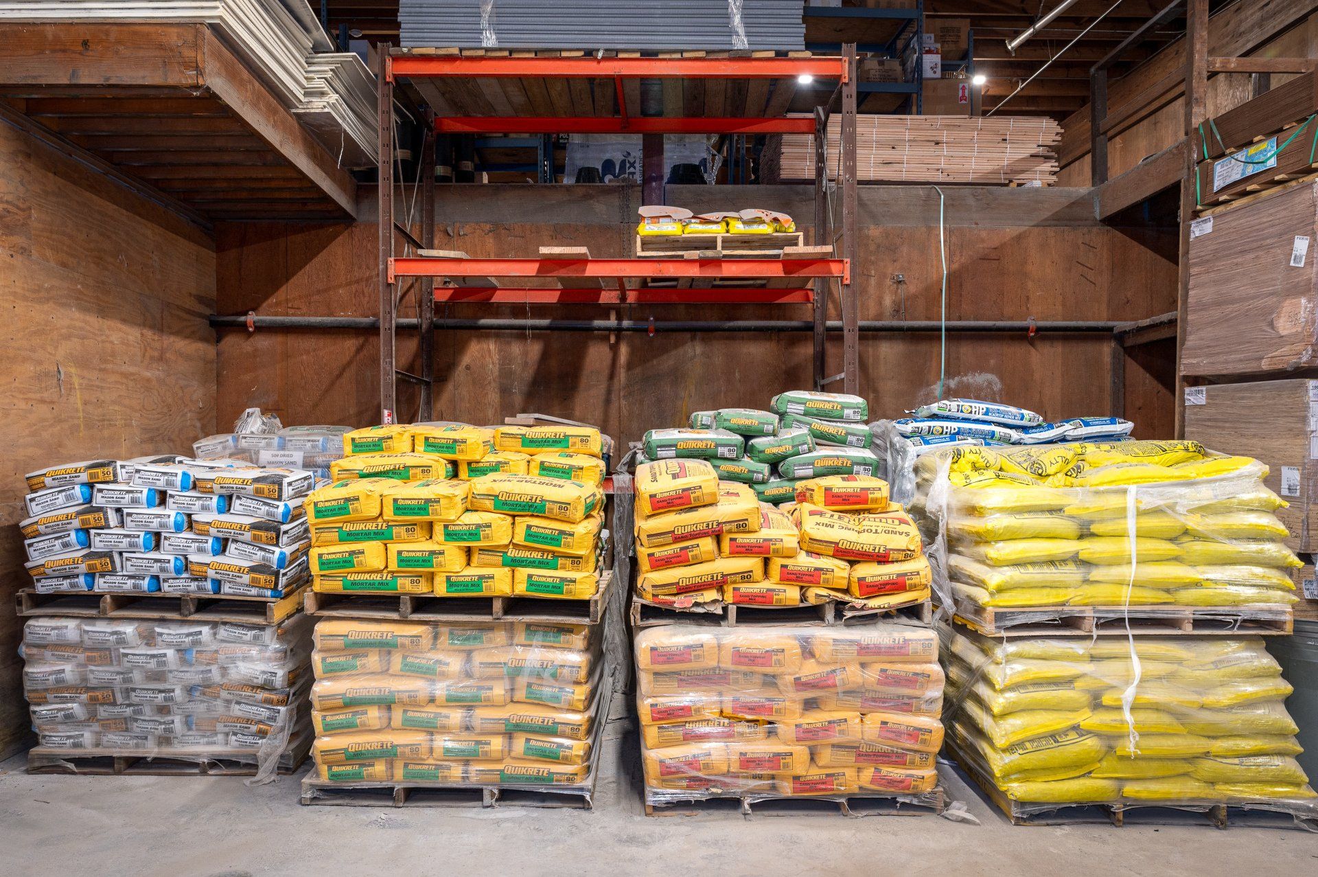 A warehouse filled with lots of bags of various types of fertilizer.