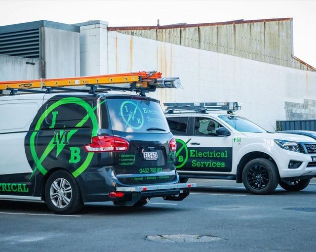 Two Electrical Services Vans Are Parked Next to Each Other in a Parking Lot — JMB Electrical Services In Port Kembla, NSW 