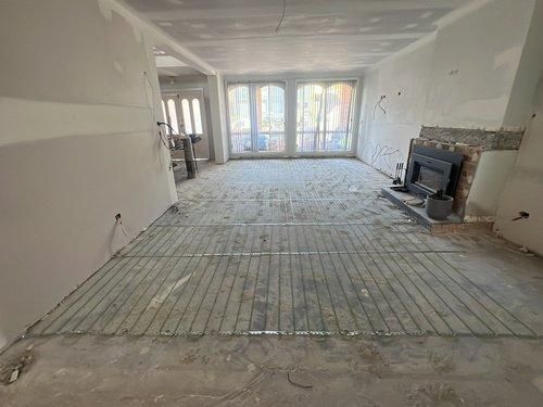 A Living Room With a Fireplace and a Wire Floor Heating System — JMB Electrical Services In Port Kembla, NSW