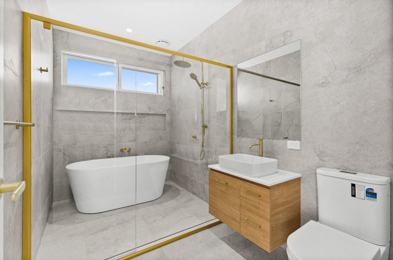 A Bathroom With a Tub , Sink , Toilet and Shower — JMB Electrical Services In Woonona, NSW