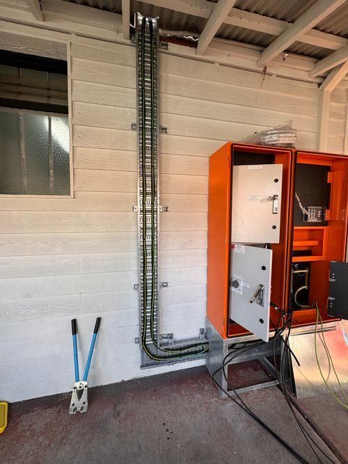 An Orange Box With the Door Open and a Bunch of Wires Coming Out of It — JMB Electrical Services In Port Kembla, NSW