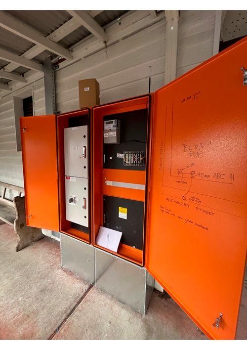 Two Orange Electrical Boxes With the Doors Open — JMB Electrical Services In Port Kembla, NSW