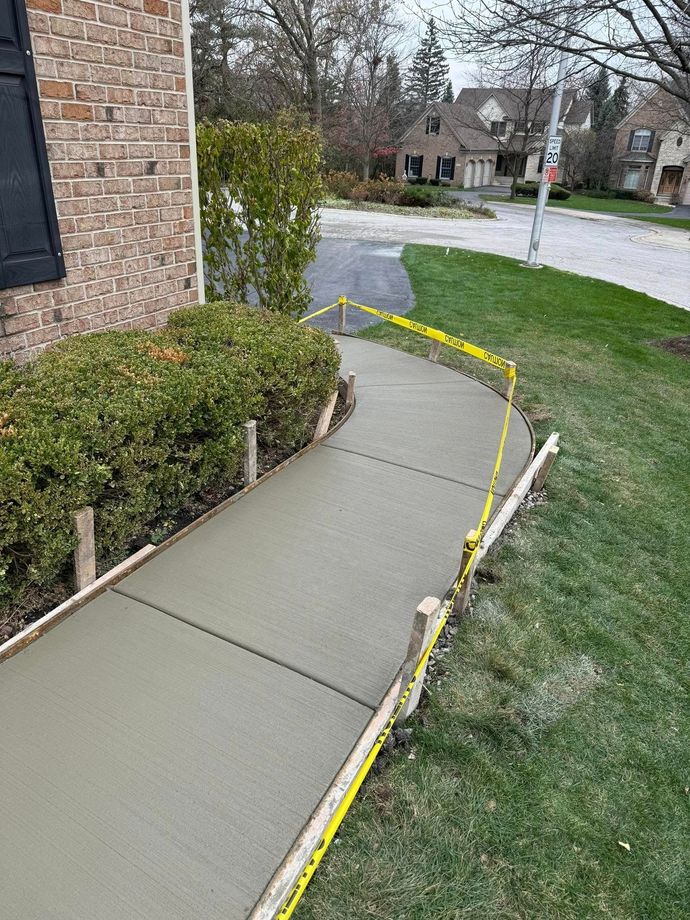 A concrete walkway is being built in front of a house.