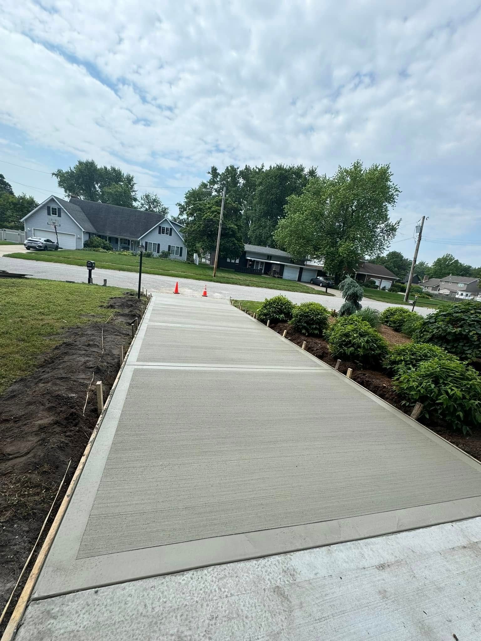 A concrete walkway is being built in front of a house.