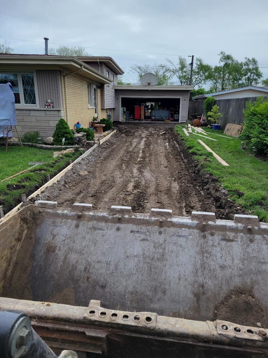 A bulldozer is removing dirt from a driveway in front of a house.