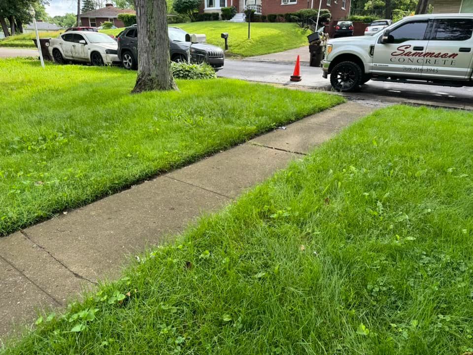 A truck is parked on the side of the road next to a sidewalk.