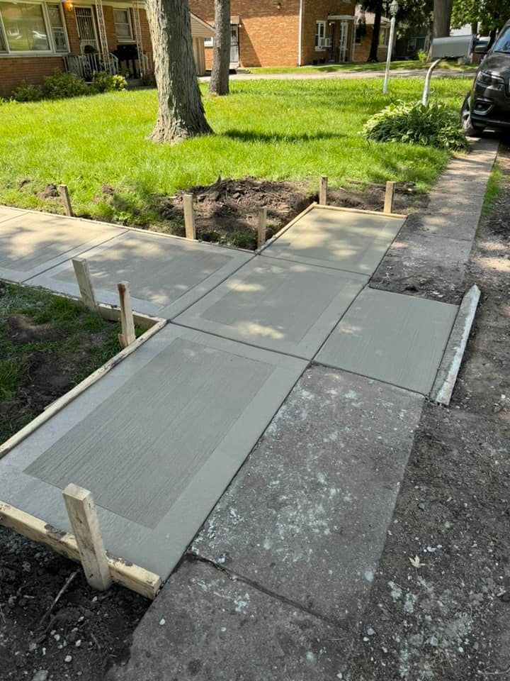 A concrete sidewalk is being built in front of a house.