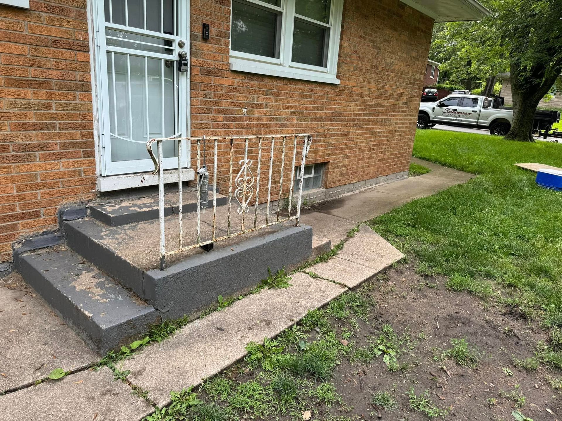 A brick house with stairs leading up to the front door.