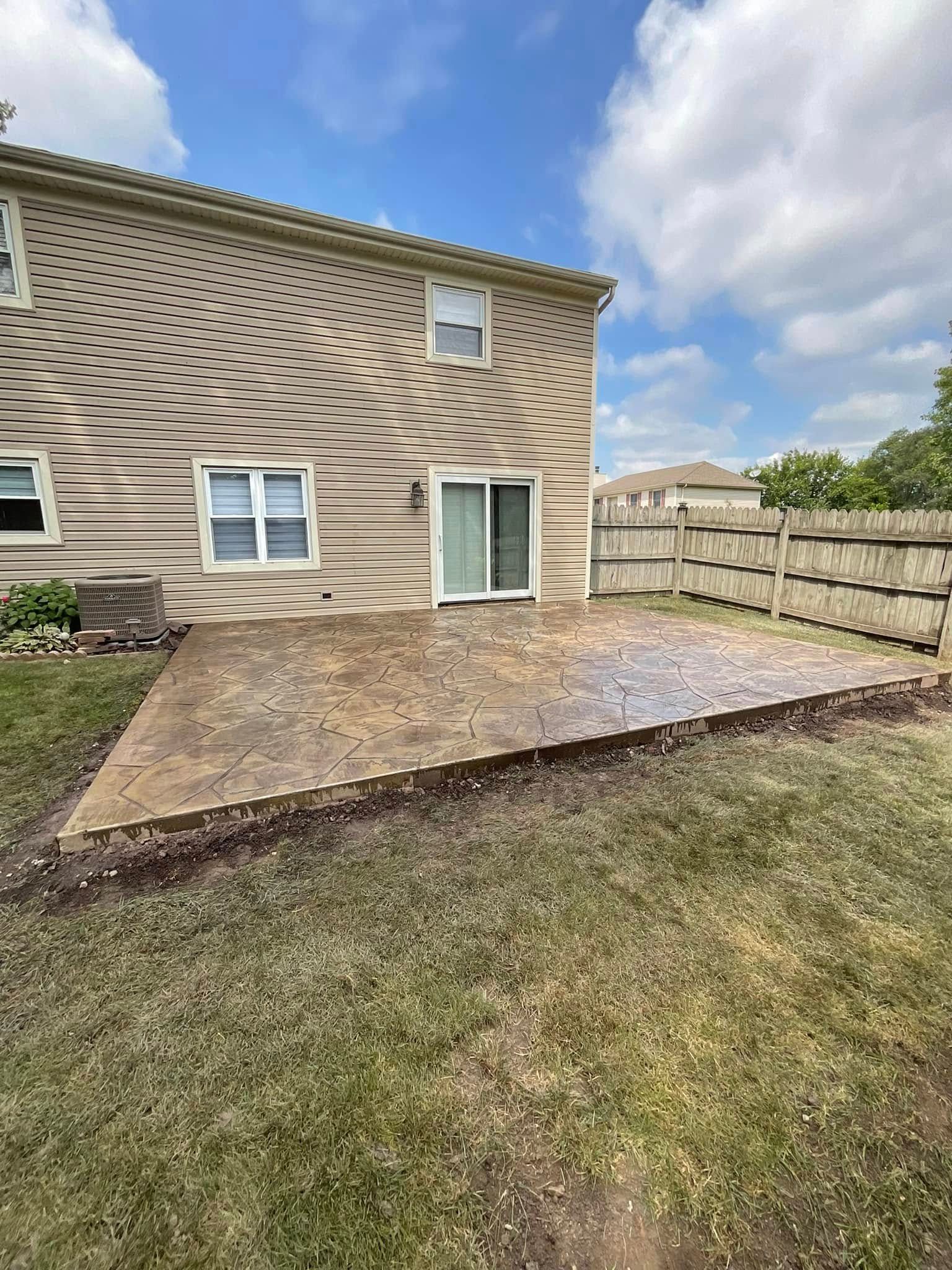 There is a patio in the backyard of a house.