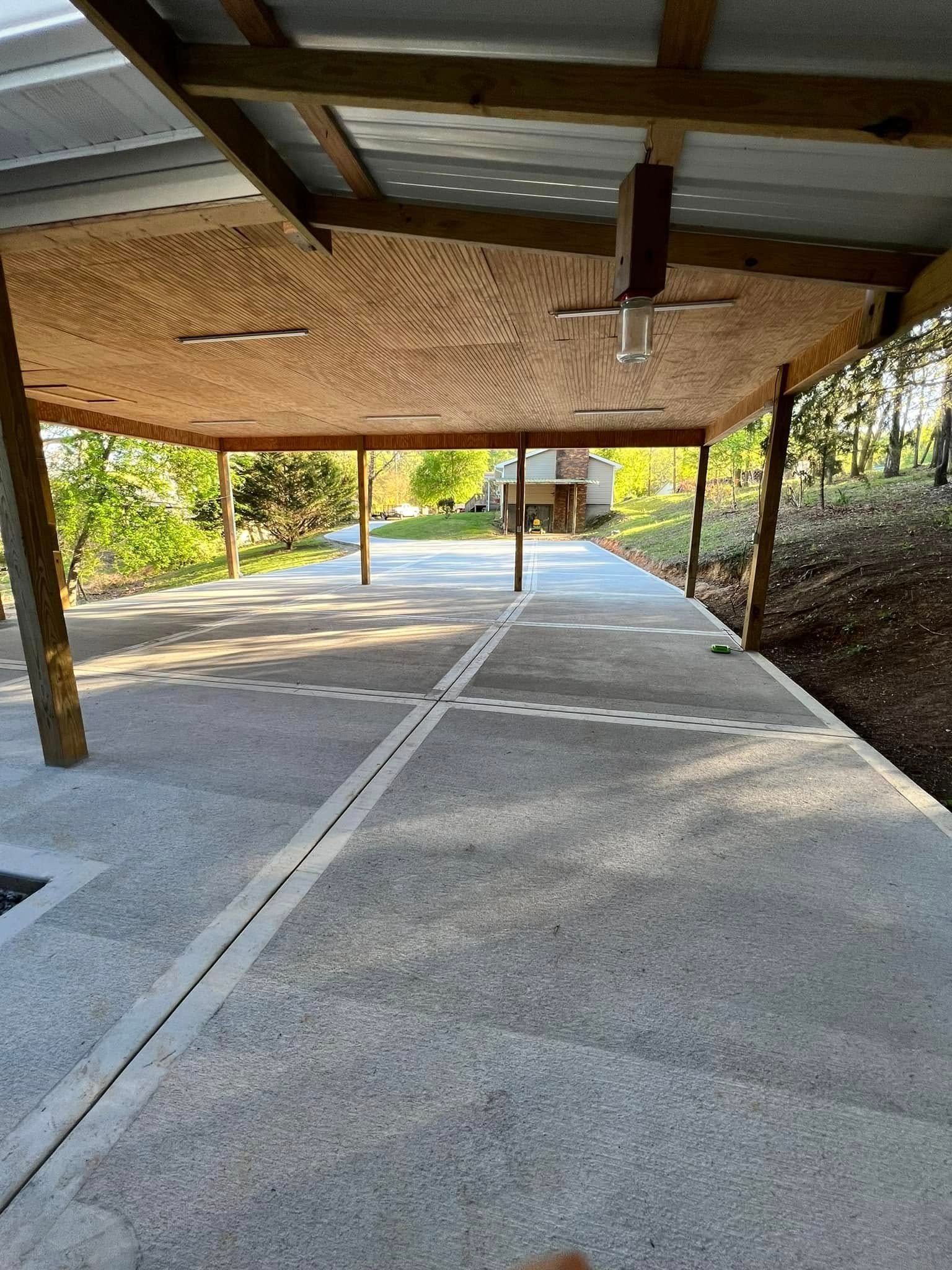 A carport with a wooden roof and a ceiling fan.