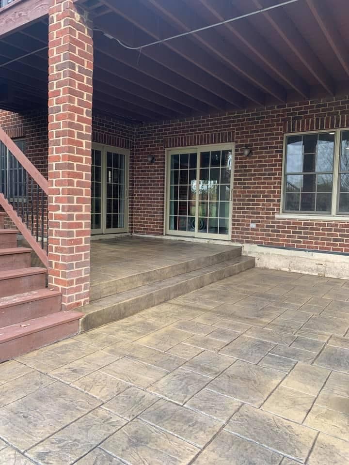 A brick house with a patio and stairs in front of it.