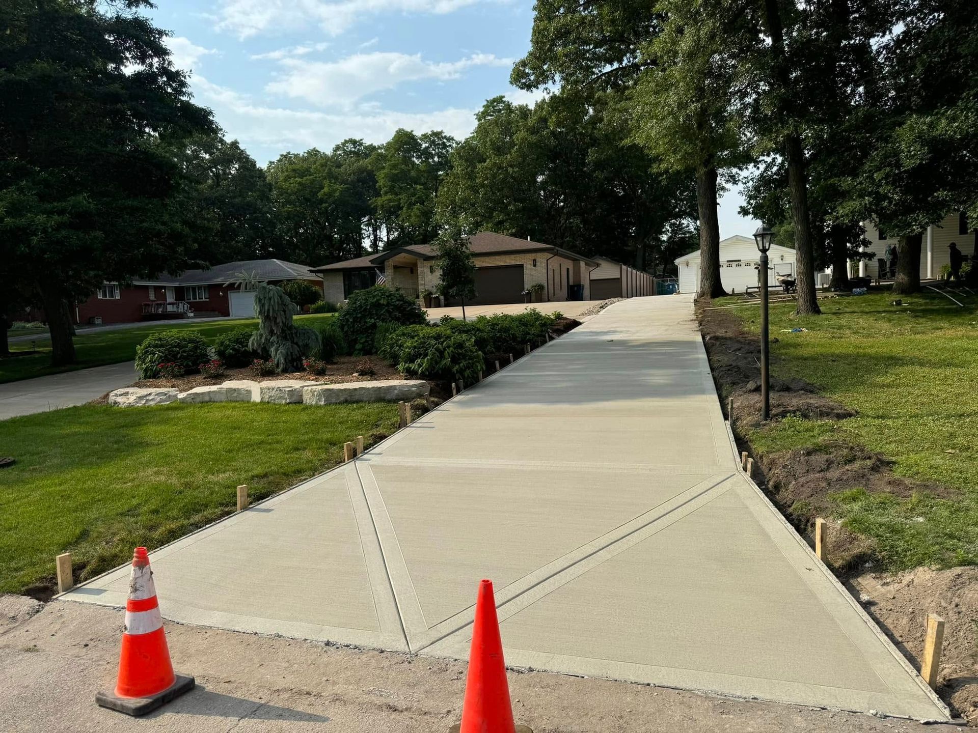 A concrete driveway is being built in front of a house.