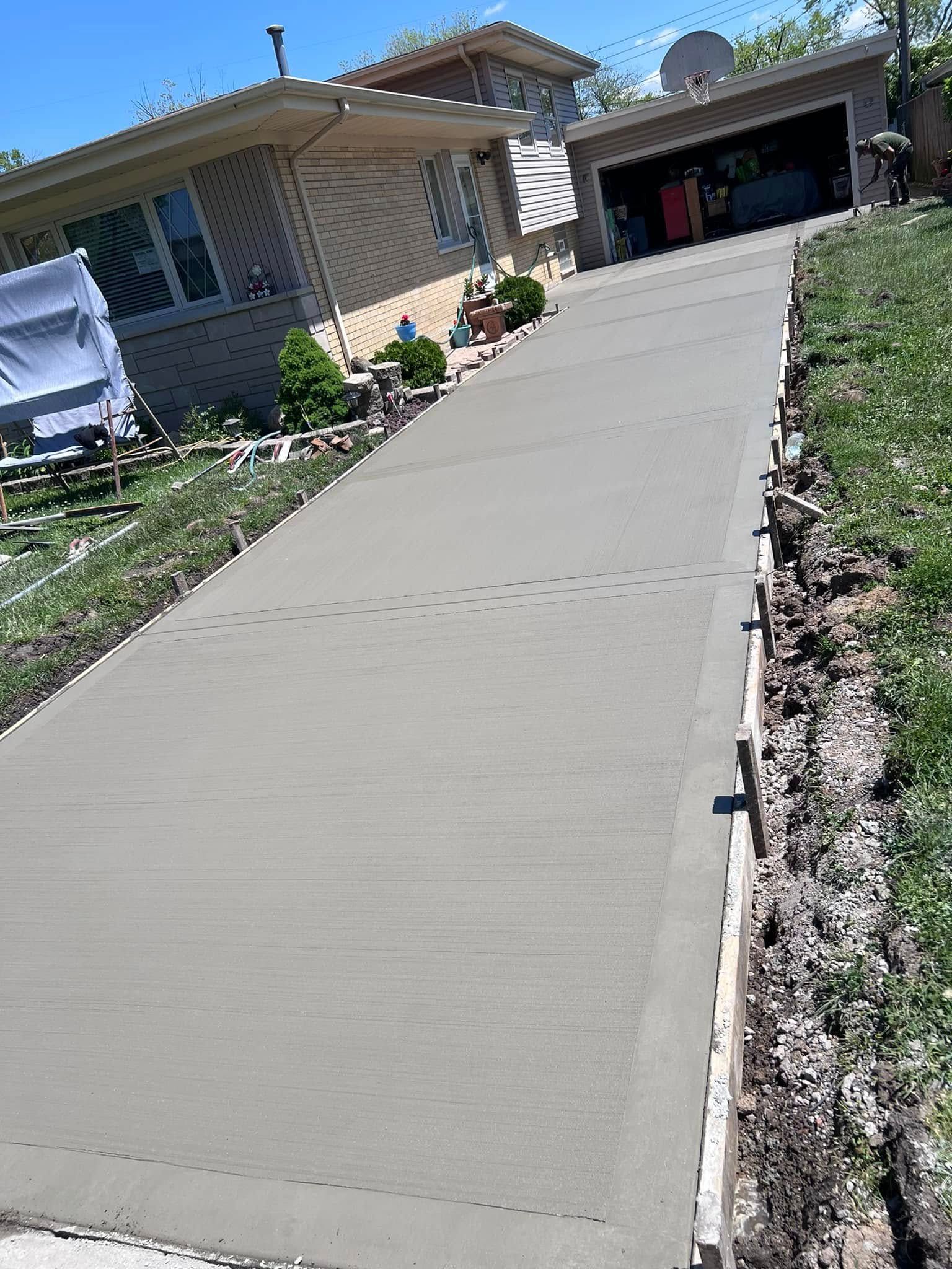 A concrete driveway is being built in front of a house.