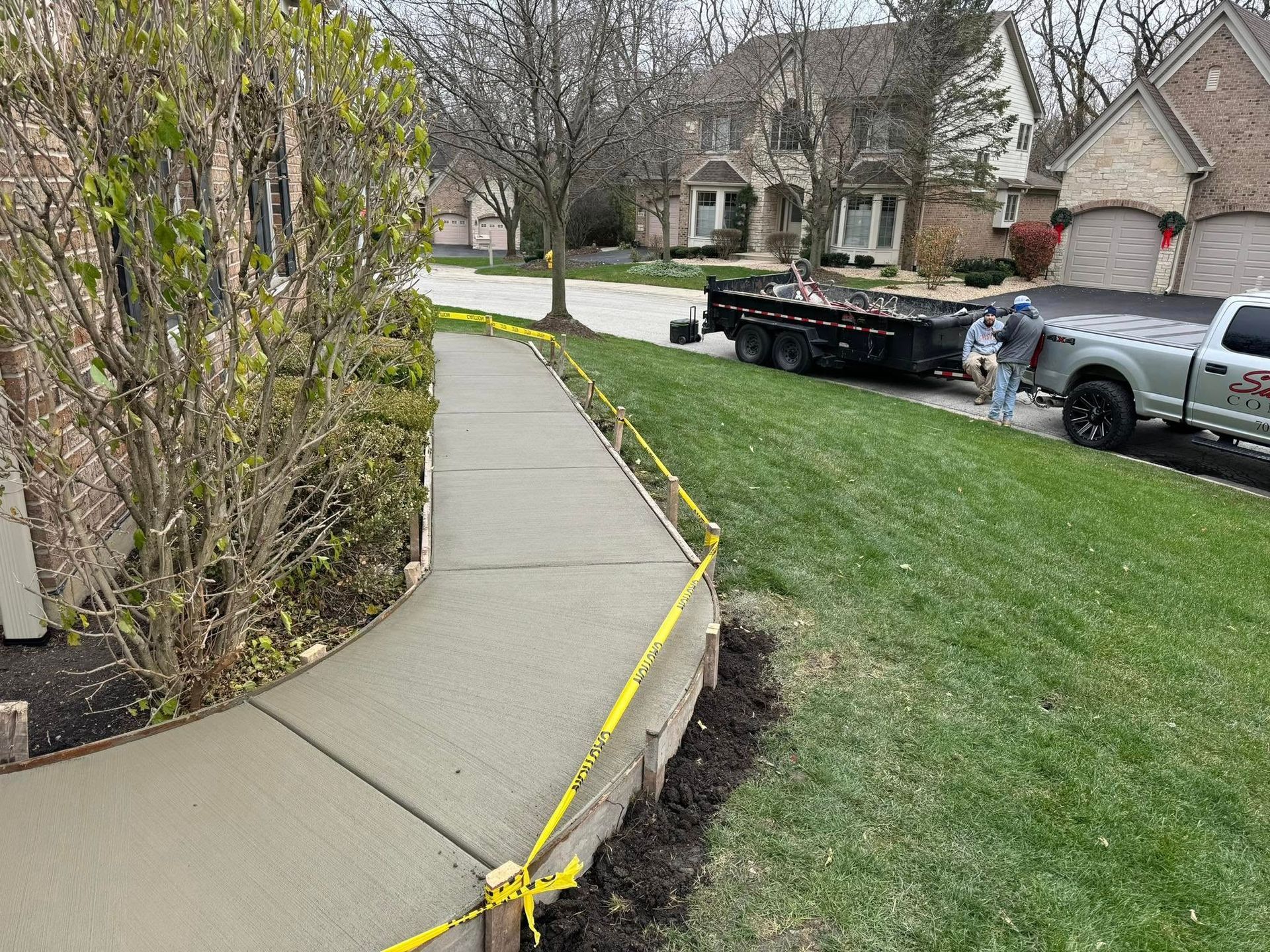 A truck is parked on the side of the road next to a sidewalk.