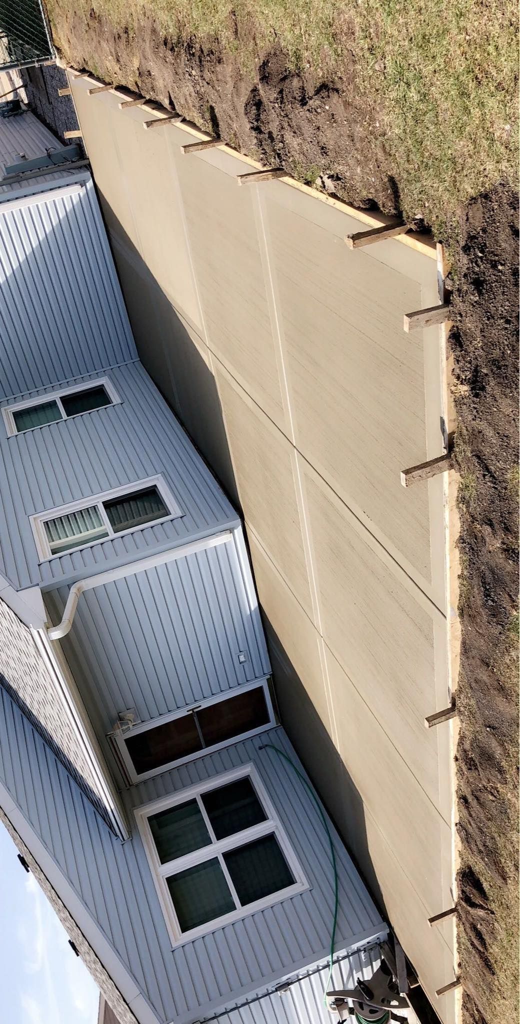 A white house is sitting on top of a dirt hill.