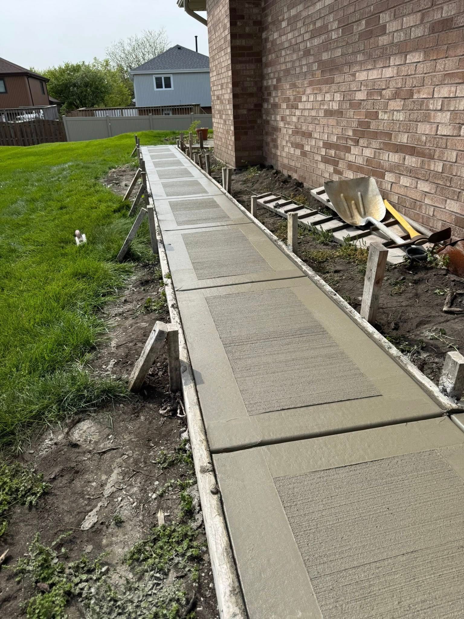 A concrete walkway is being built in front of a brick building.