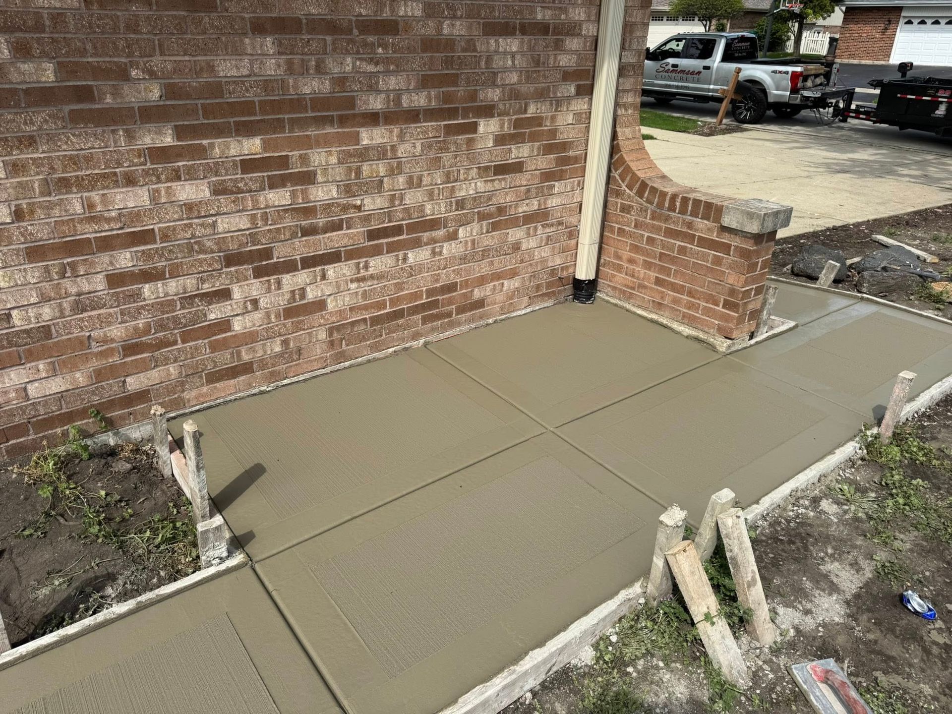 A concrete walkway is being built in front of a brick building.