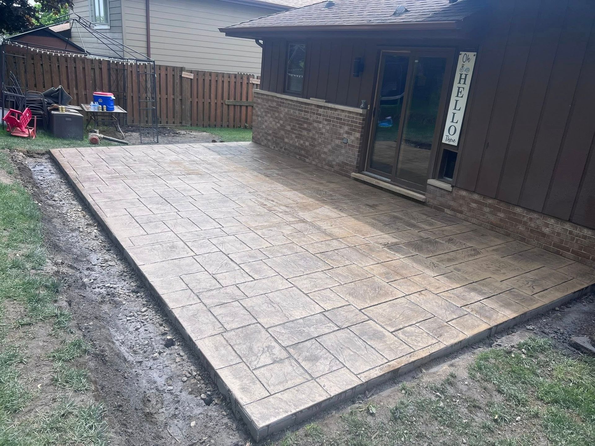 A patio is being built in the backyard of a house.