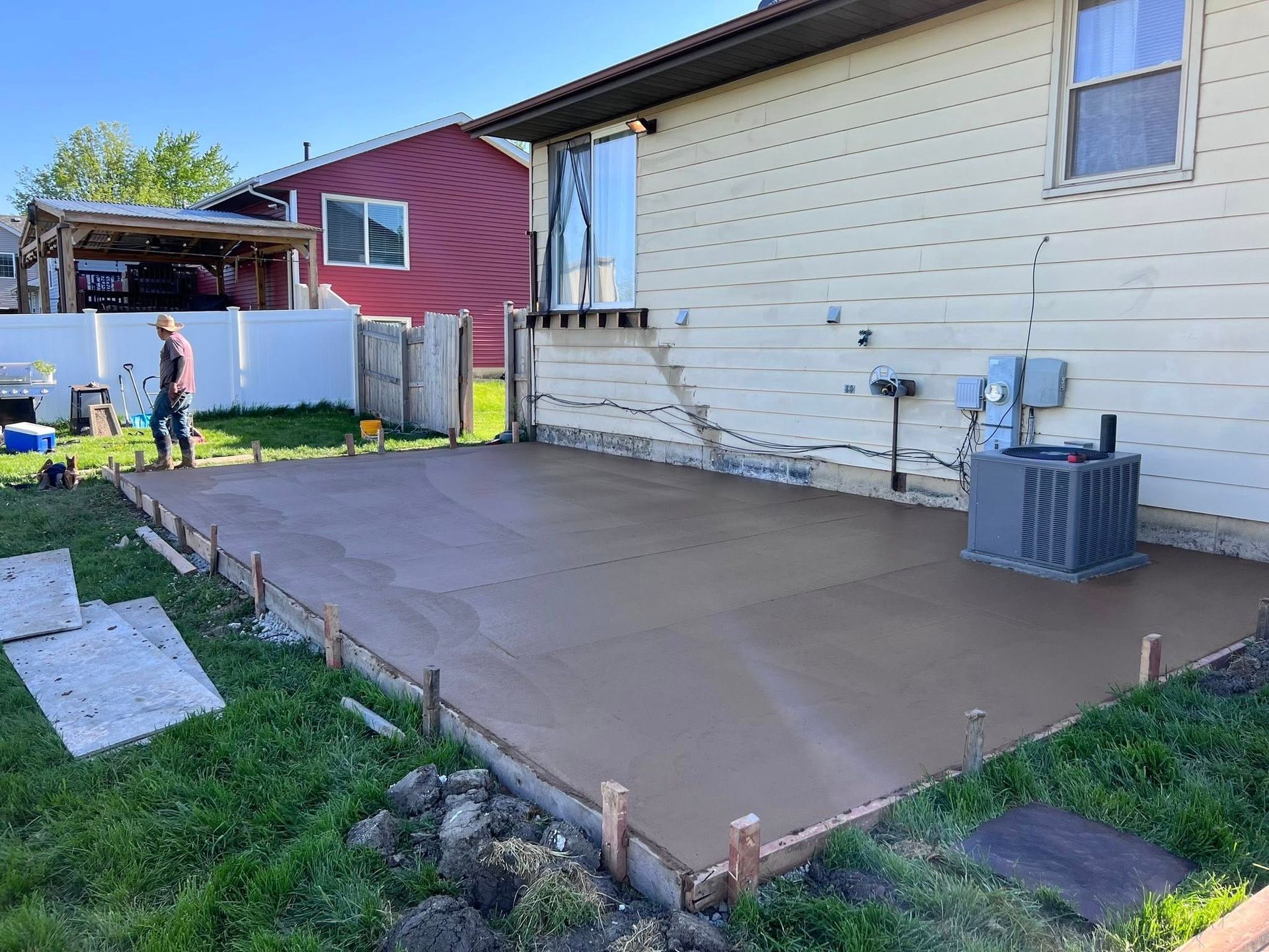 A man is standing on a concrete patio in front of a house.
