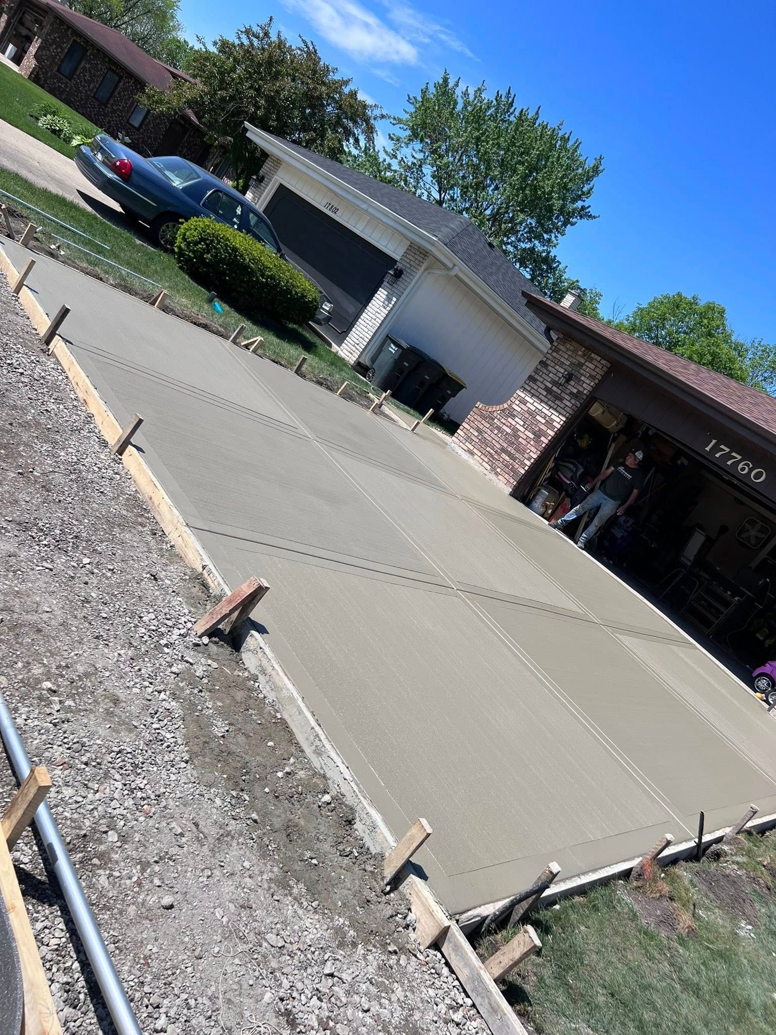 A concrete driveway is being built in front of a house.