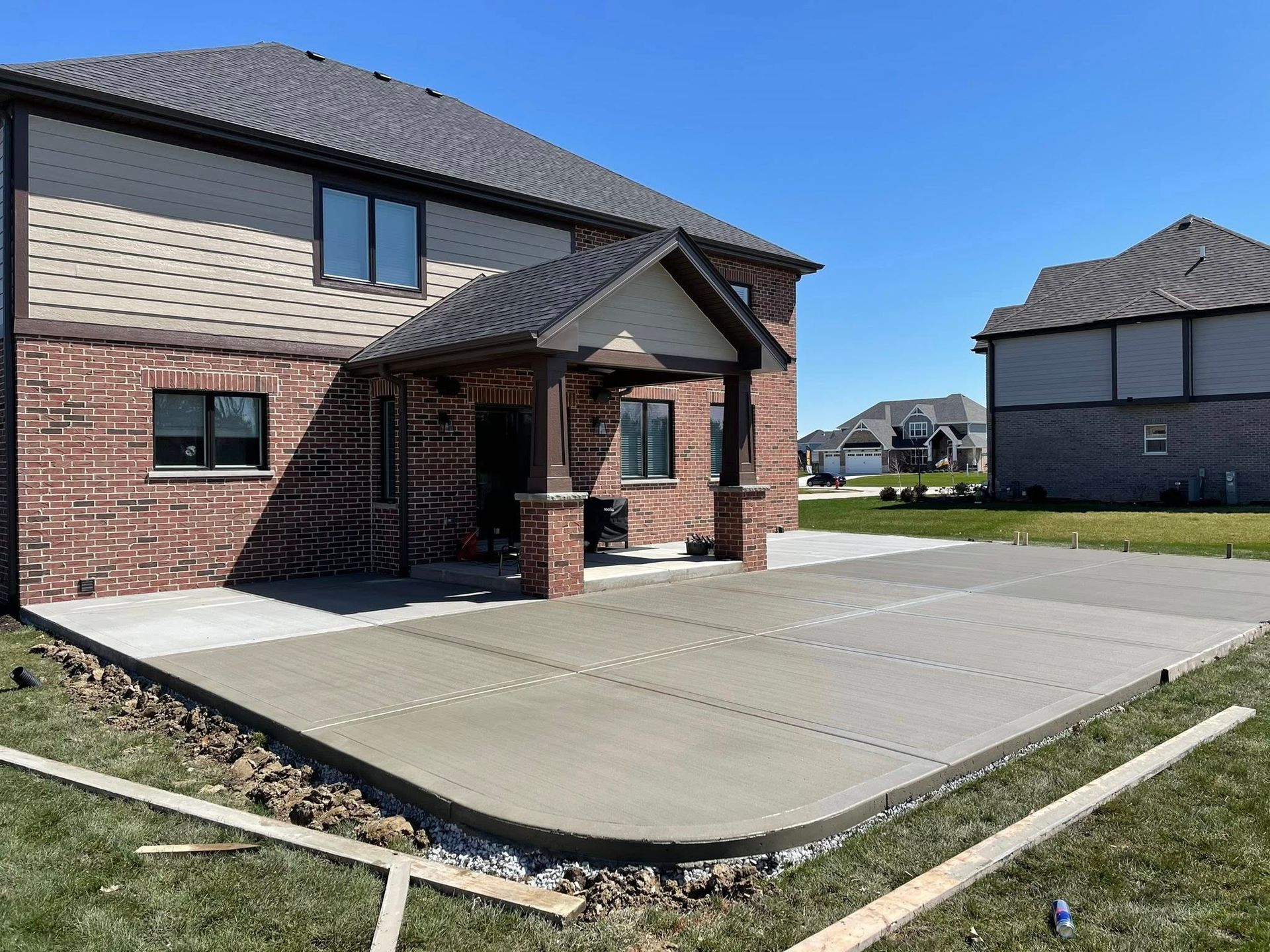 A brick house with a concrete driveway in front of it.