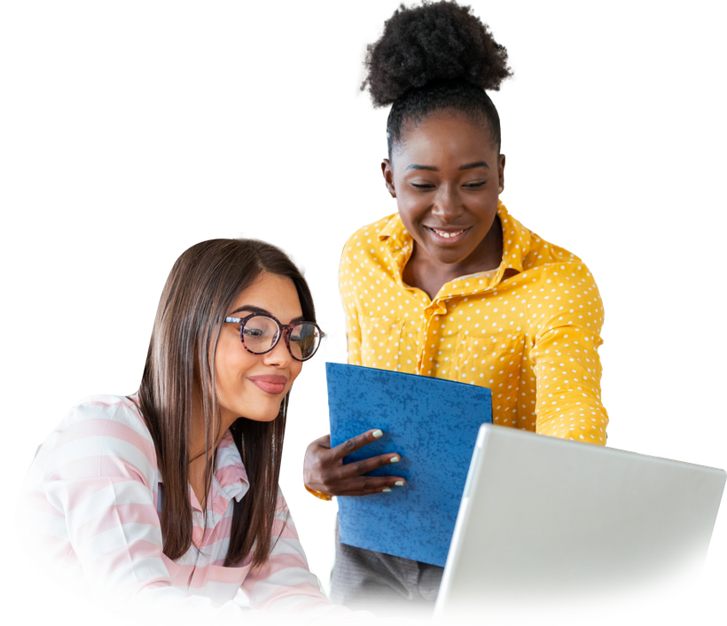 Two women are looking at a laptop together and smiling.
