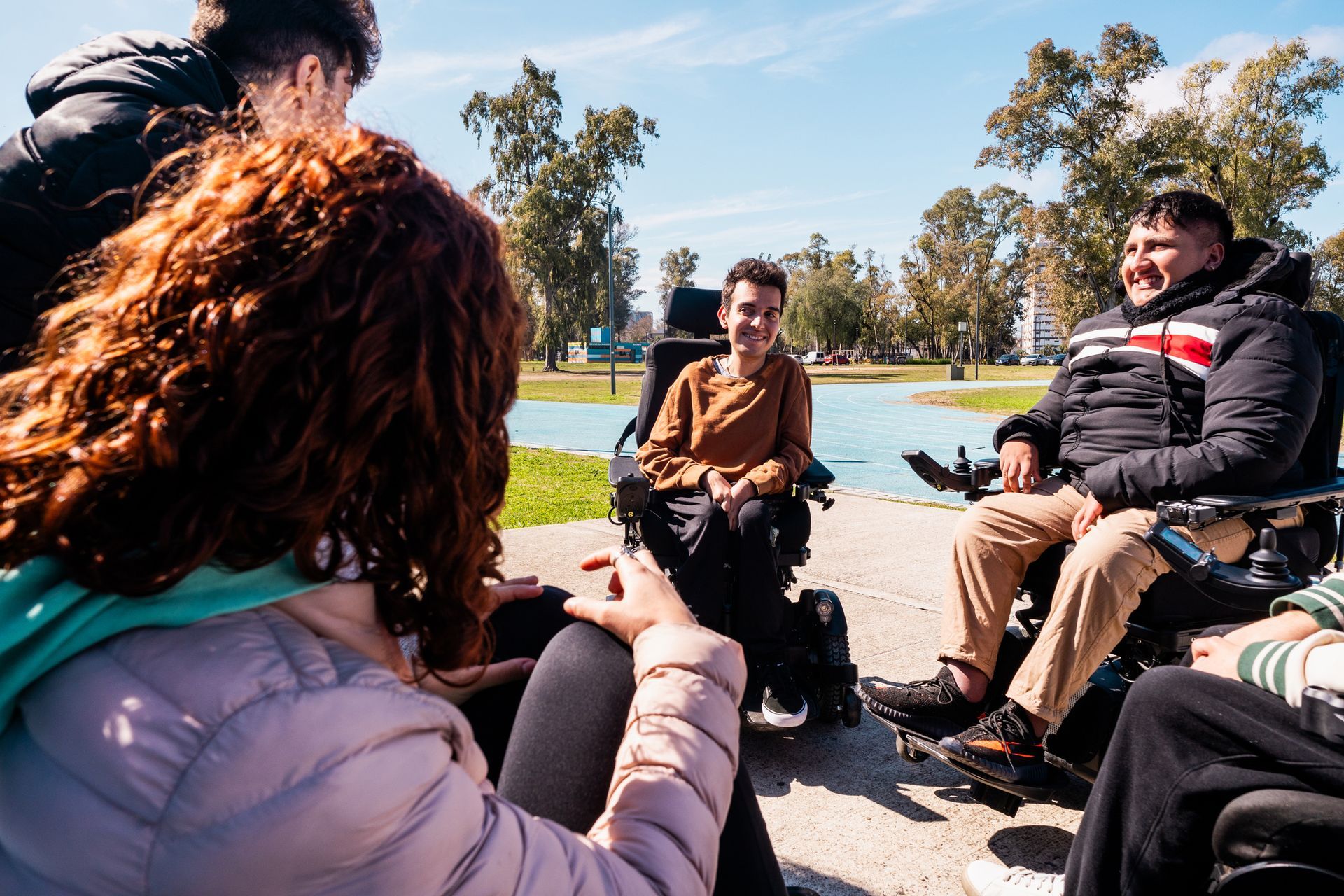 A group of people in wheelchairs are sitting in a circle.