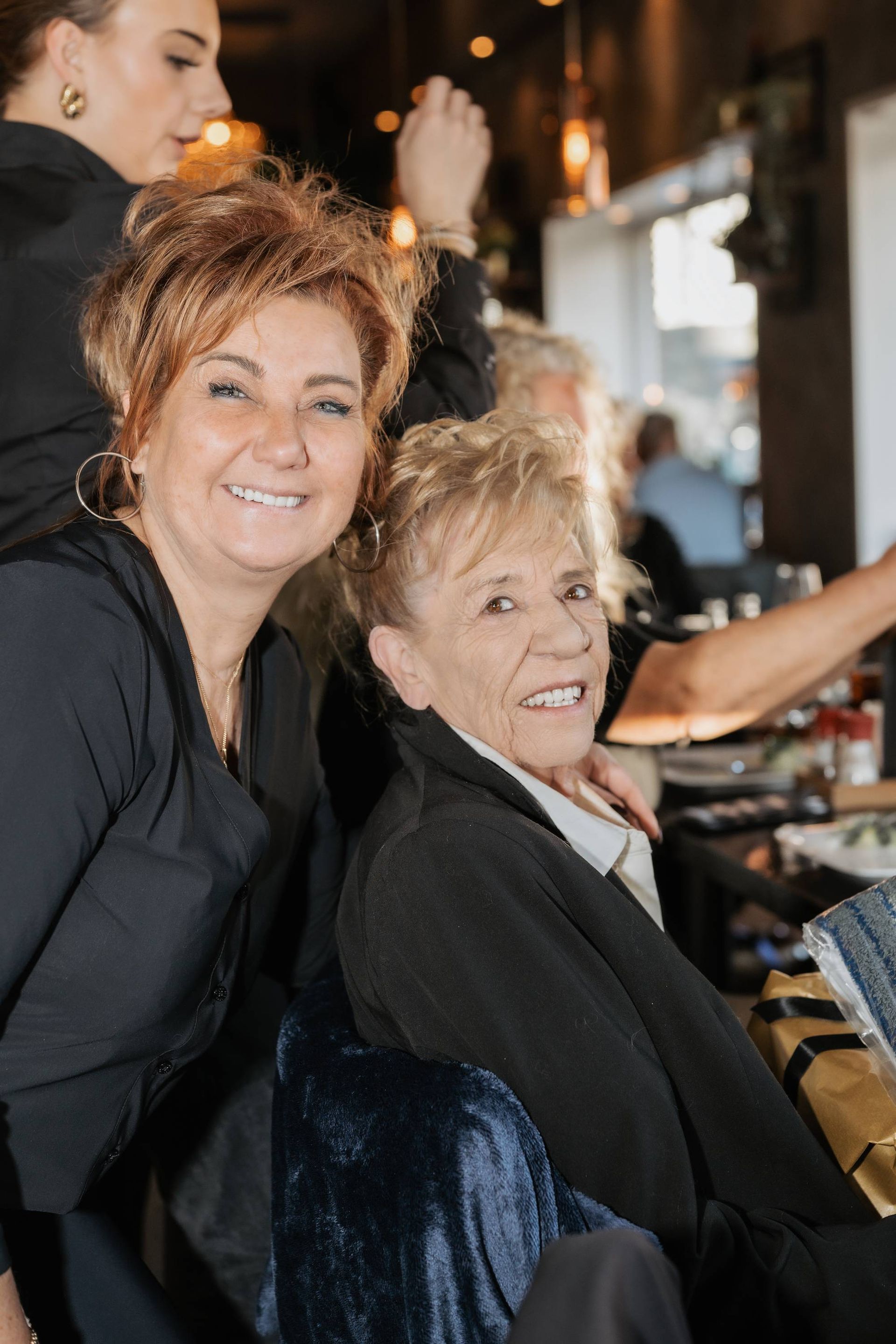 Een groep mensen in zwarte uniformen poseert voor een bakstenen gebouw met kerstversiering.