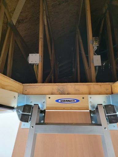 Attic access: Werner folding ladder descends. Wooden frame with electrical boxes.