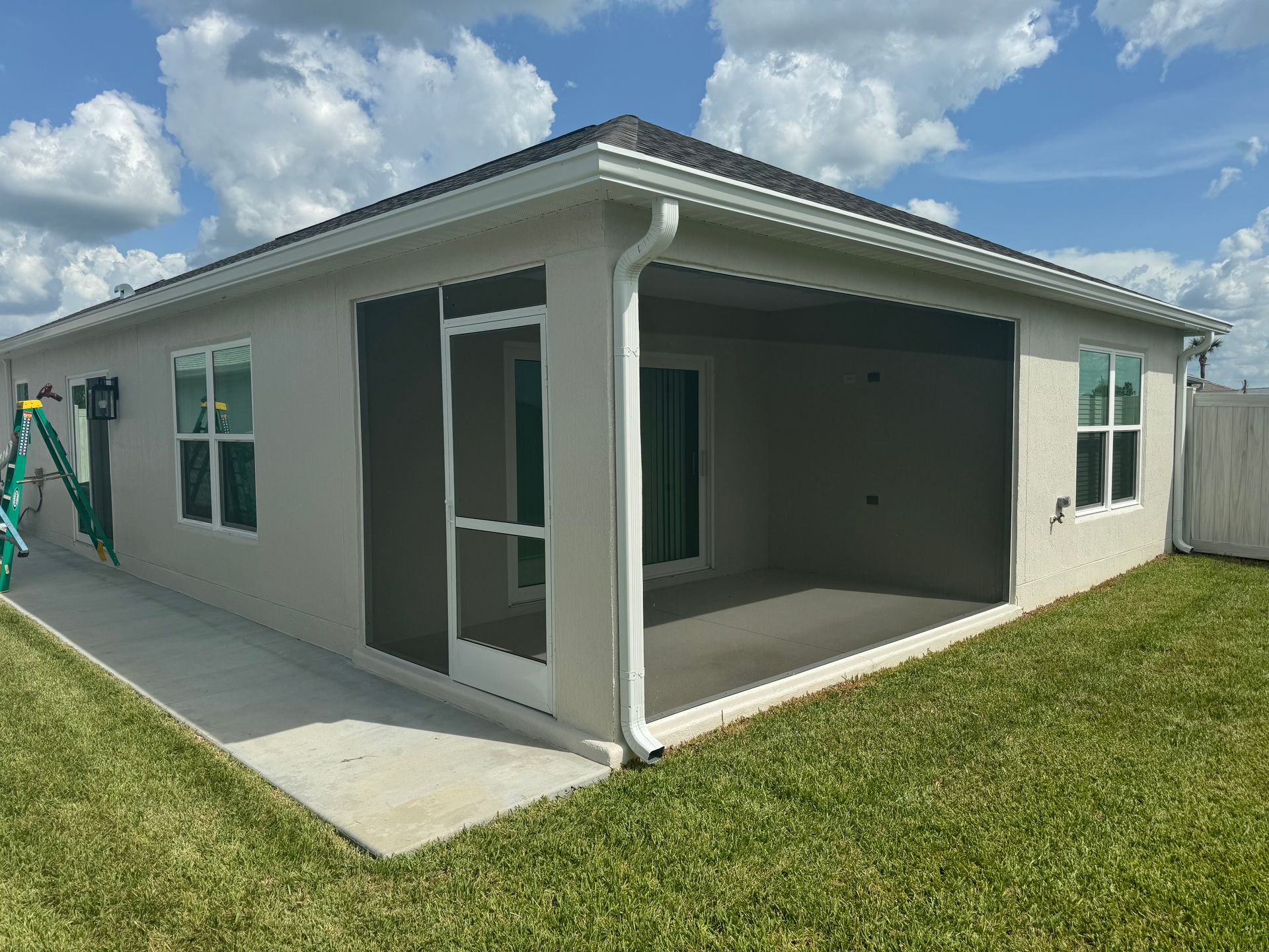 A beige house with an open patio under a cloudy sky.