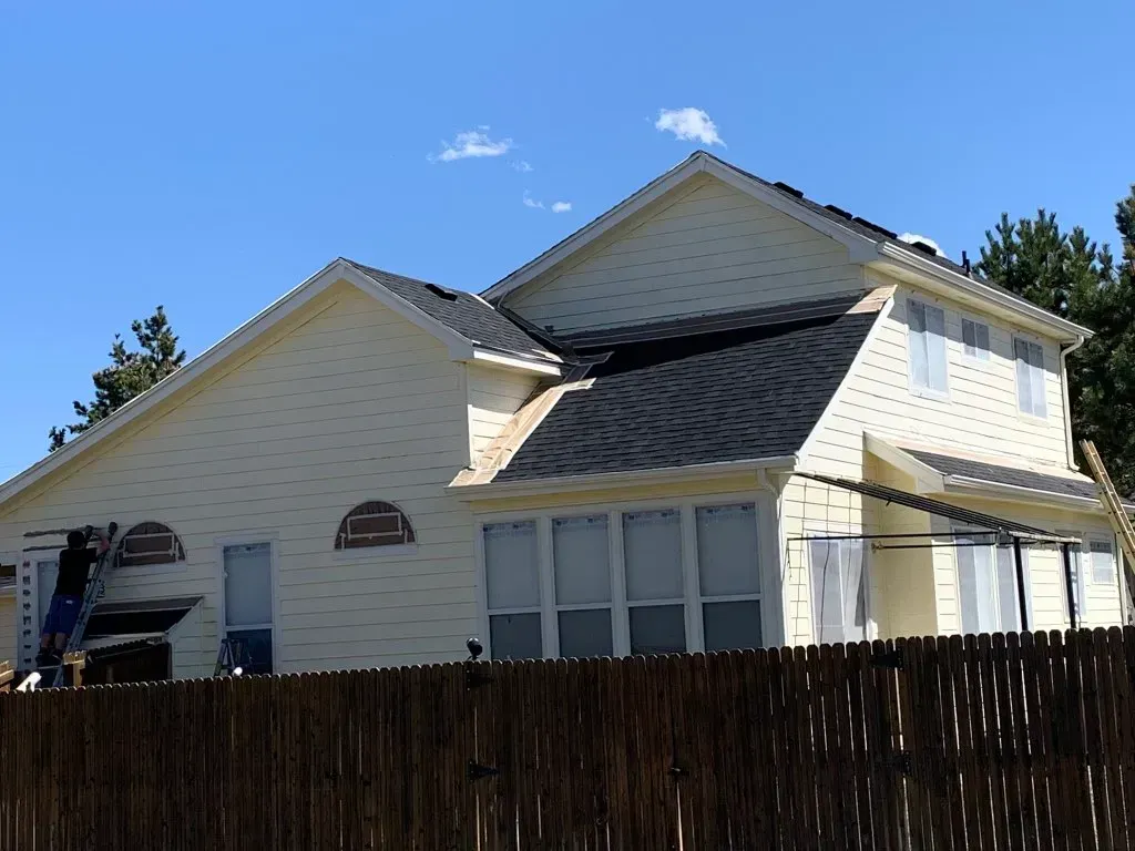 A white house with a wooden fence in front of it