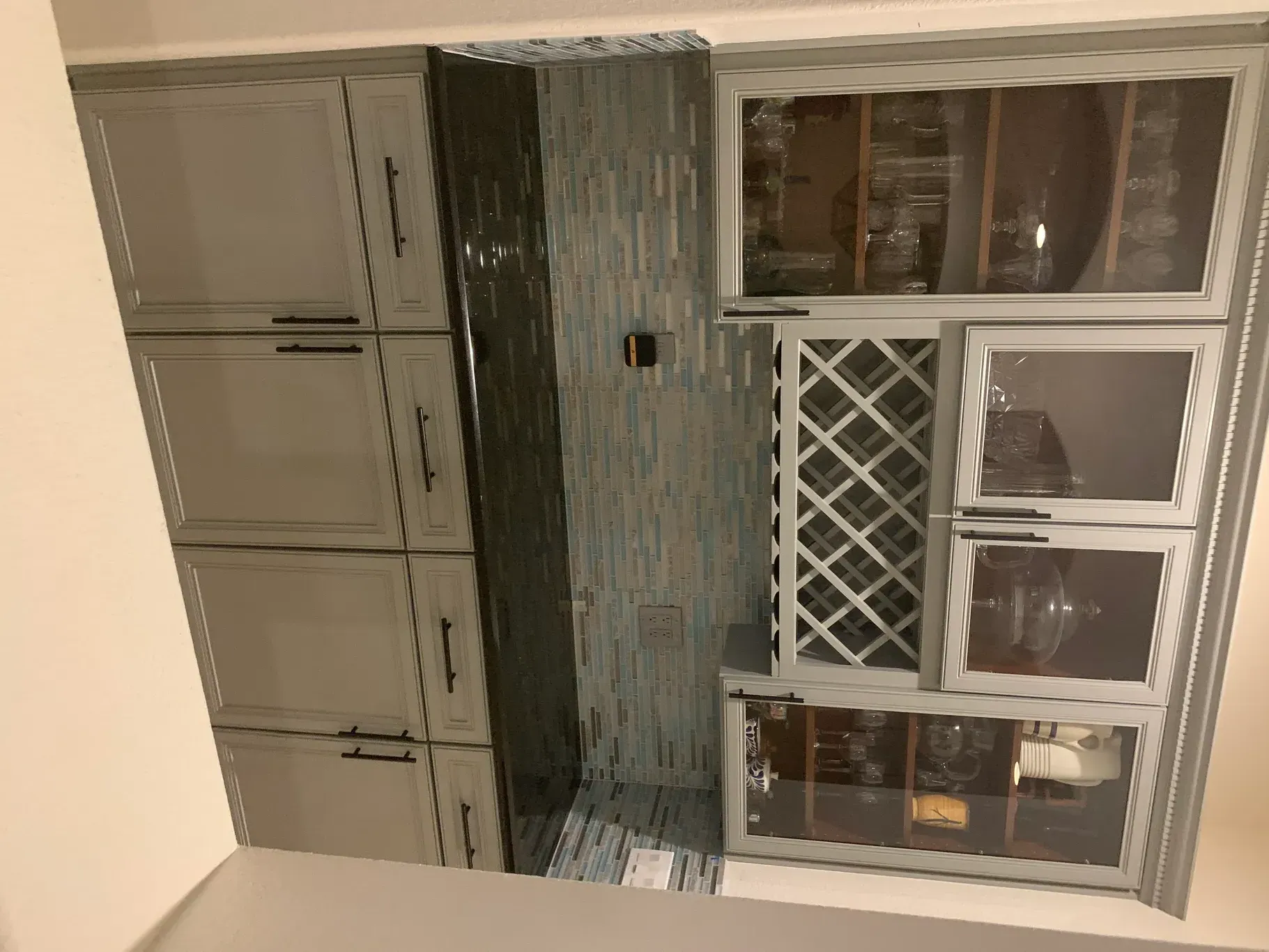 A kitchen with a wine rack and a refrigerator.