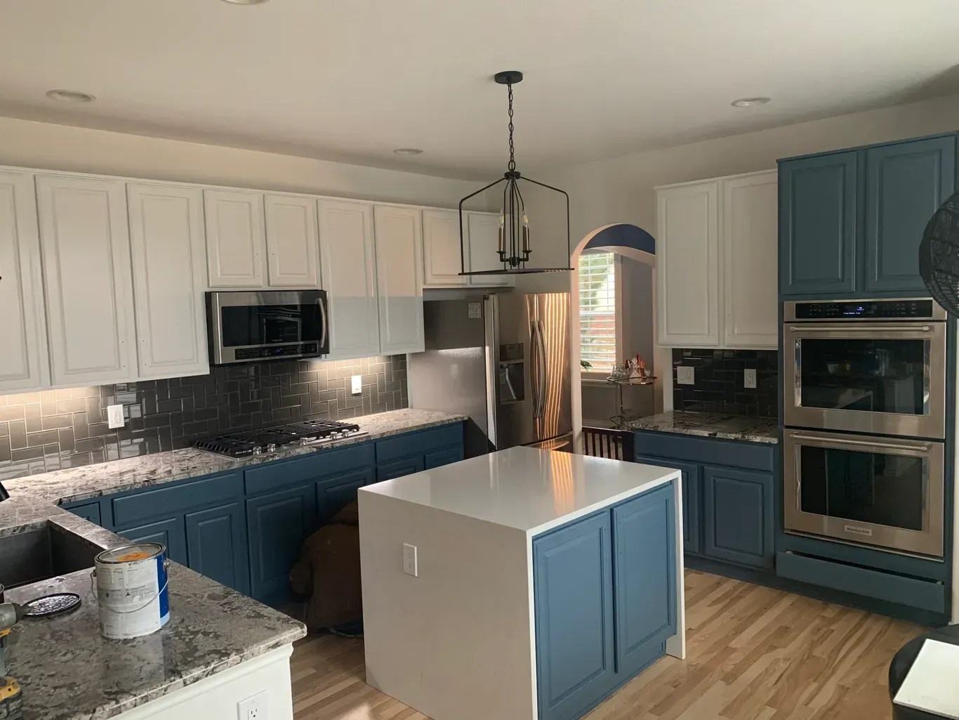 A kitchen with blue cabinets and white counter tops is being remodeled.