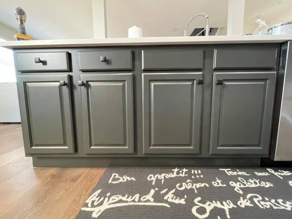 A kitchen with gray cabinets and a rug that says aujourd 'hui soupe de poisson