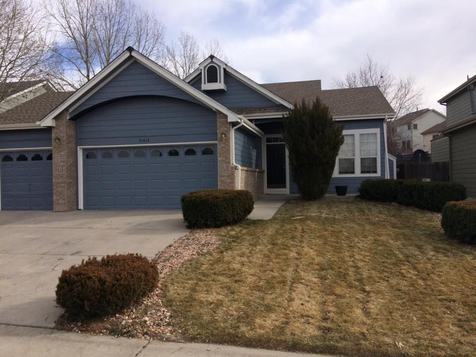 A house with a blue garage door and a lawn in front of it