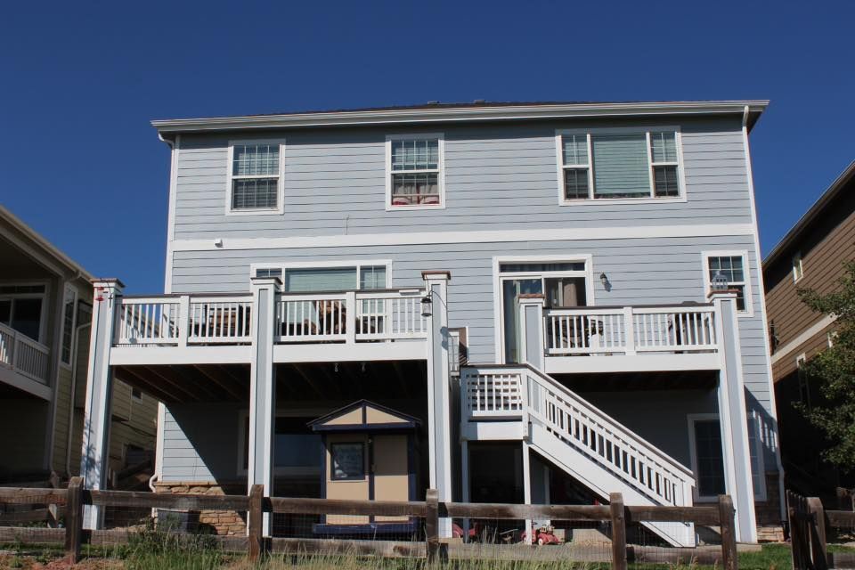 The back of a house with a large deck and stairs