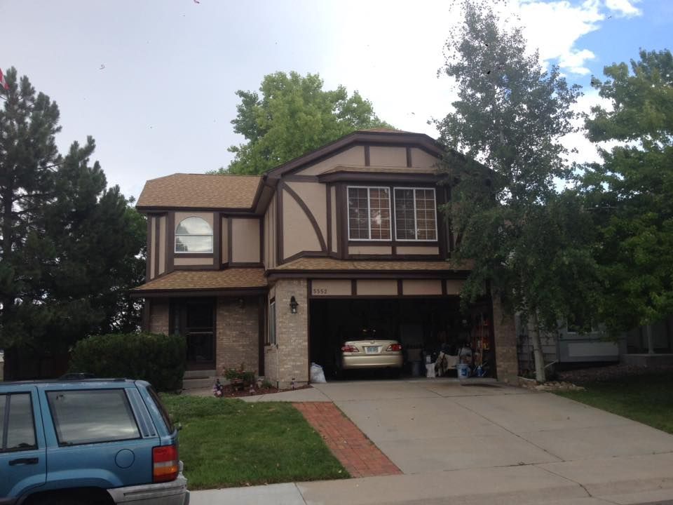 A blue jeep is parked in front of a house