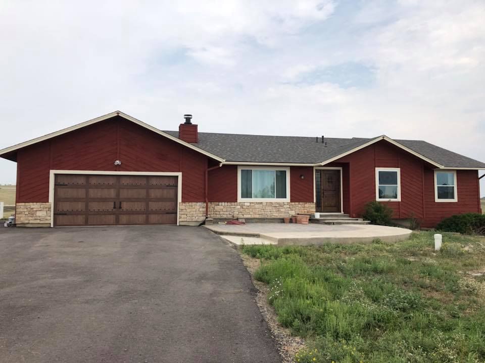 A red house with a garage and a driveway